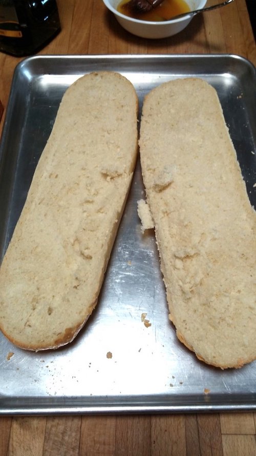 12 Easy Bread Recipes - Round-Up Page 8 1 loaf of french bread cut in half length-wise to be made into garlic bread. Sitting on an aluminum cookie sheet.