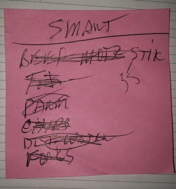 Pink piece of paper with a shopping list scrawled on it - a bad example of a shopping list