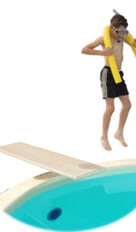 A boy jumping off of a diving board into a swimming pool.
