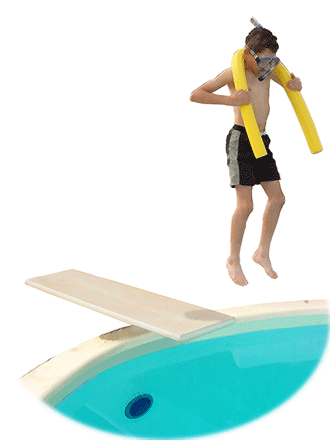 A boy jumping off of a diving board into a swimming pool.