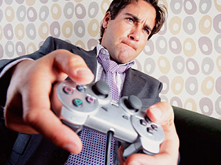 Young man in a suit intently playing video games.