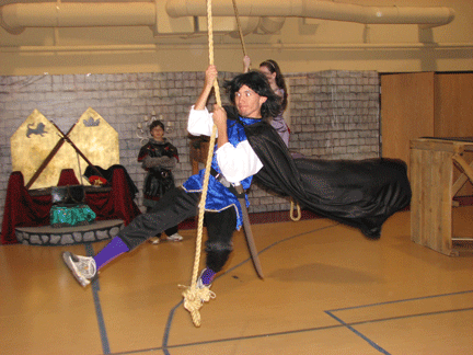 Joe swinging on a rope while dressed in Medieval garb.