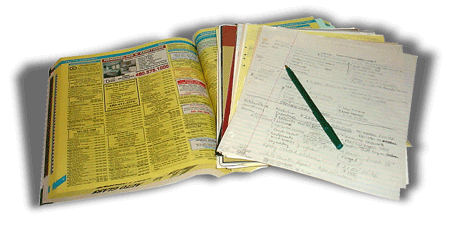 A phone book and pile of notes for researching contractors.