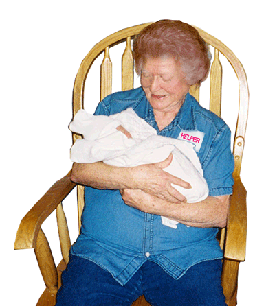 A grandma rocking a baby in the rocking chair.