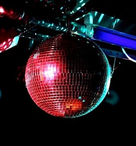 Red disco ball hanging from a black ceiling.