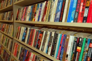 hundreds of paperback books on wooden shelves.