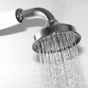 A chrome shower head with water cascading out of it.