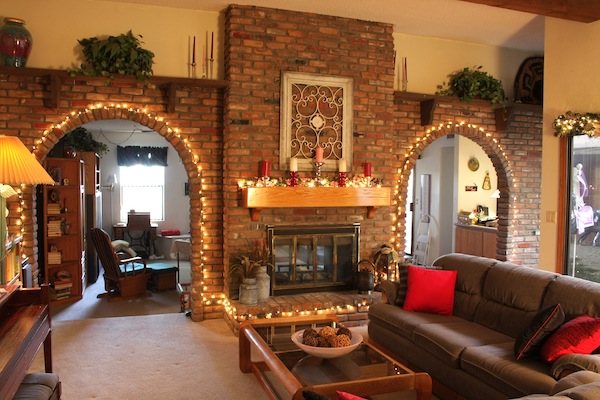 Airbnb living room with decorated brick fireplace.