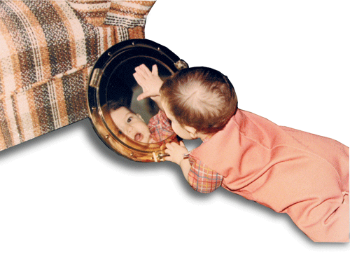 How to Save Money Raising A Baby | 5 Clever Tips 2 Baby John looking at a mirror by a couch.