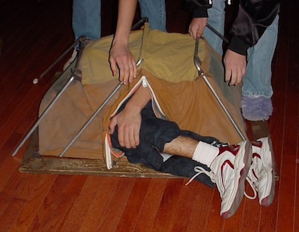How to Make A Christmas Budget that Makes your Holidays Jingle with Joy 3 A memorable Christmas Present. Teen age boy curled up inside of a small sample camping tent.