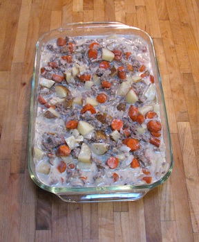 Pork Main Dish Recipes (Ham and Sausage too) – Delicious to Eat! 3 A 9x13 inch glass baking dish filled with ground beef hash with potatoes and carrots, sitting on a maple cutting board counter top.