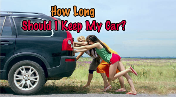 How long Should I Keep My Car? - Should I Keep My Car or Sell It? 3 women pushing their black car next to a grassy field.