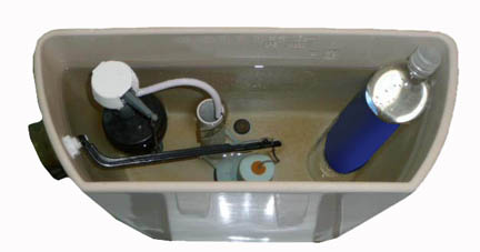 A white porcelain toilet tank with a bottle of water in it to save water when flushing.