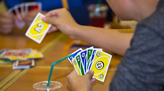 Family Game Night Ideas: 46 Activities and Games That Are Fun & Cheap 2 Uno card game being played on game night.