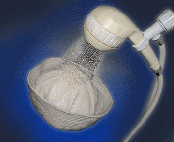A white shower head spraying water on a sailor's cap.