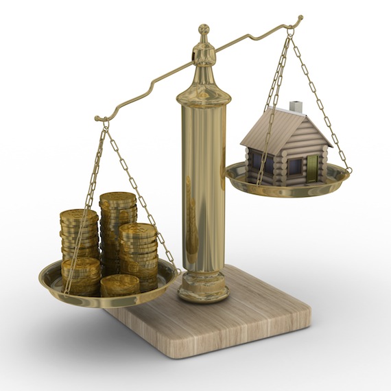 A brass scale with coins on one side and a house on the other.
