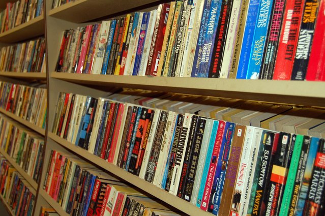 Inexpensive Summer Activities - For Kids & Families 8 hundreds of paperback books on wooden shelves.