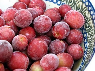Frozen red grapes in a bowl.