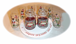A collection of nut cracker glasses, a holiday plate and christmas candles.