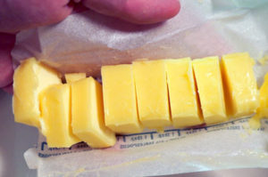 A stick of yellow margarine cut into slices - tablespoon sized.
